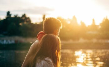 Couple watching the sunset beside water