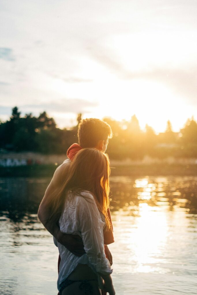 Couple watching the sunset beside water