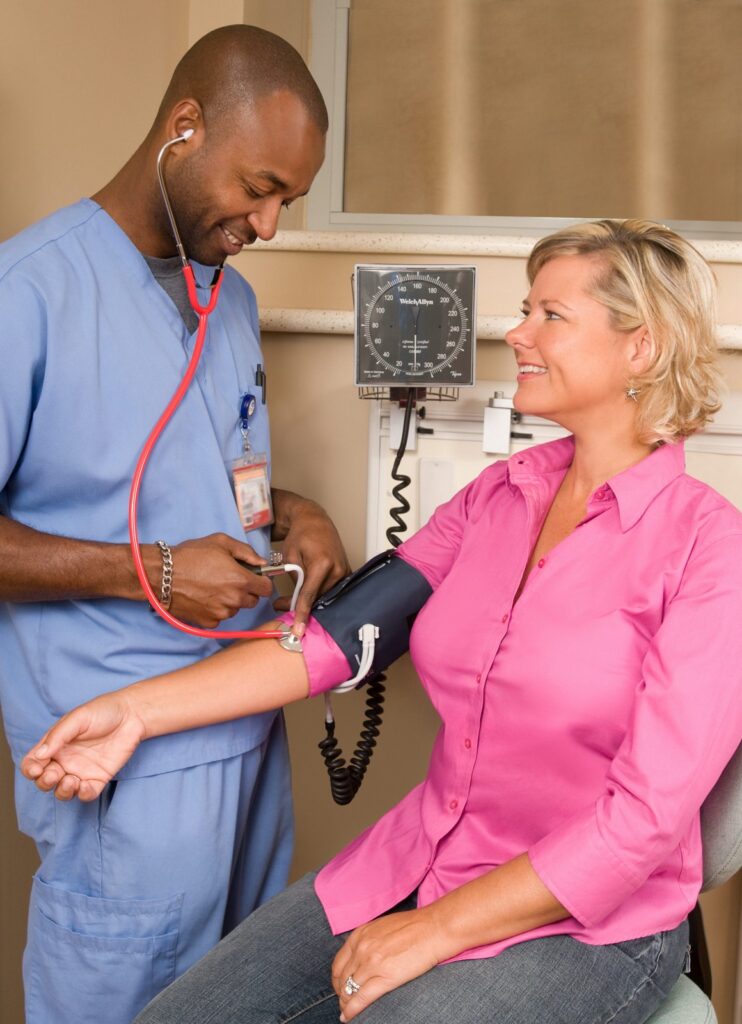 Healthcare worker measuring a patient’s blood pressure