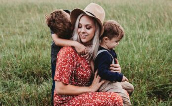 man and two children on grass field