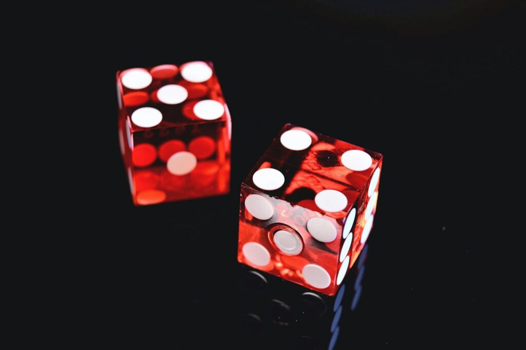 Two red dice on a dark background