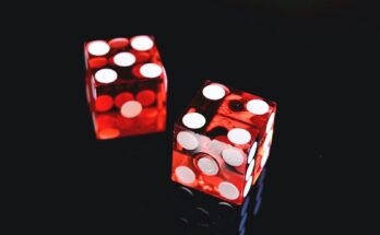 Two red dice on a dark background