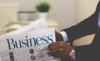 person wearing suit reading business newspaper