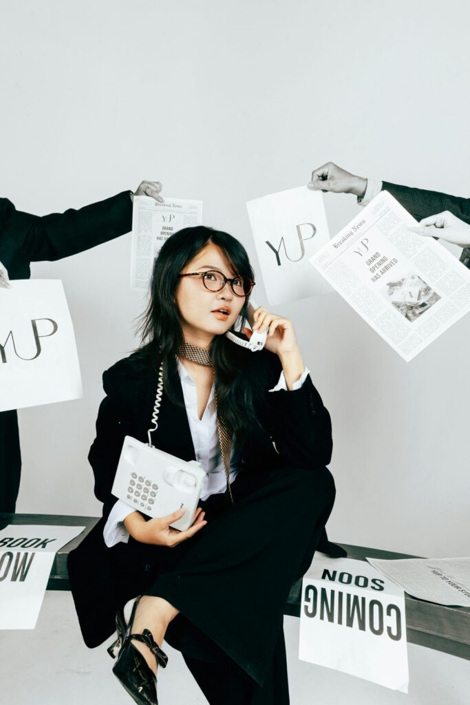 Woman in suit talking on vintage phone surrounded by papers