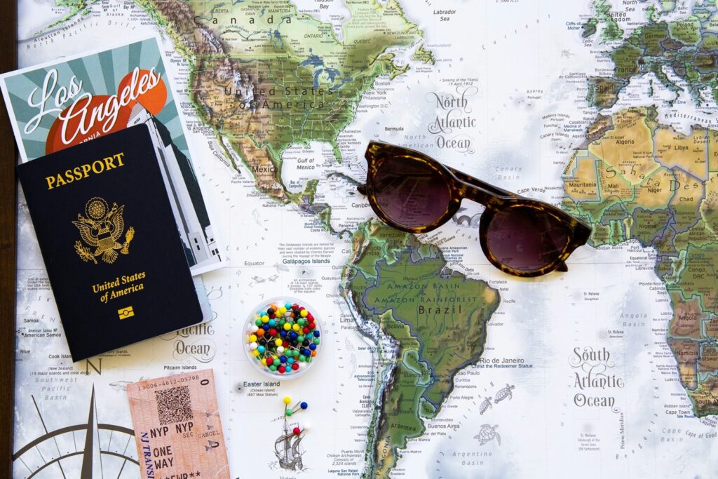 Passport and sunglasses on a world map