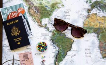Passport and sunglasses on a world map