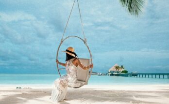 Traveler sitting on a swing above a tropical beach