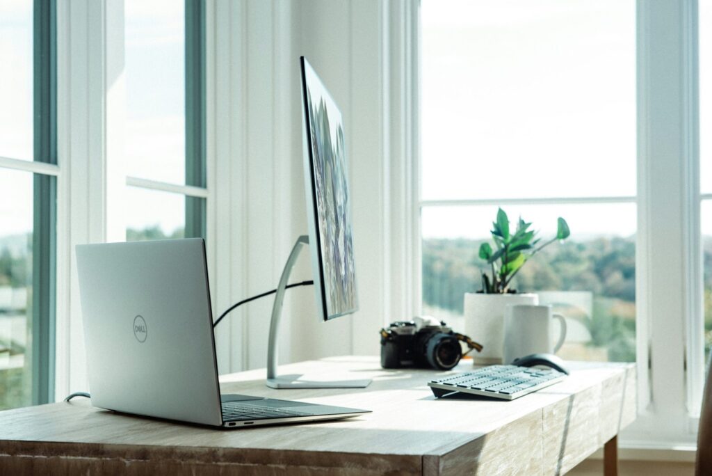 Computer and camera on a bright office desk