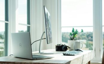 Computer and camera on a bright office desk