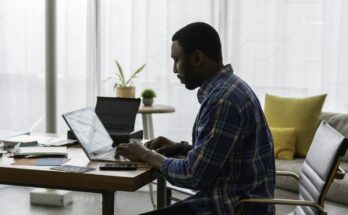 Man using a laptop at a home office desk