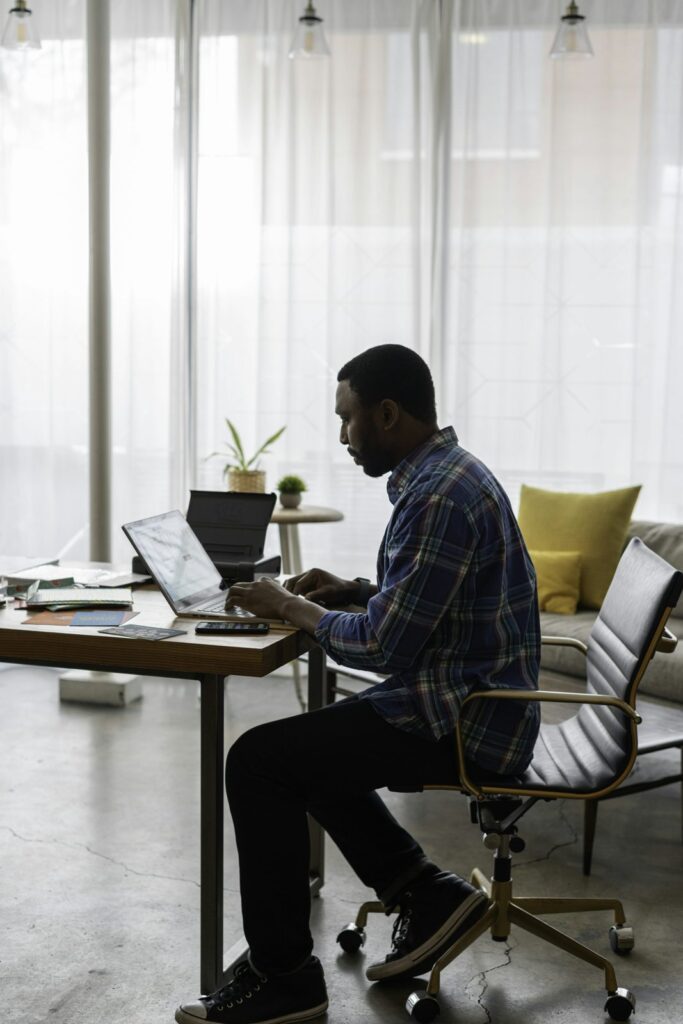 Man using a laptop at a home office desk